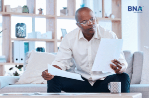 Man in glasses reviewing paperwork at home
